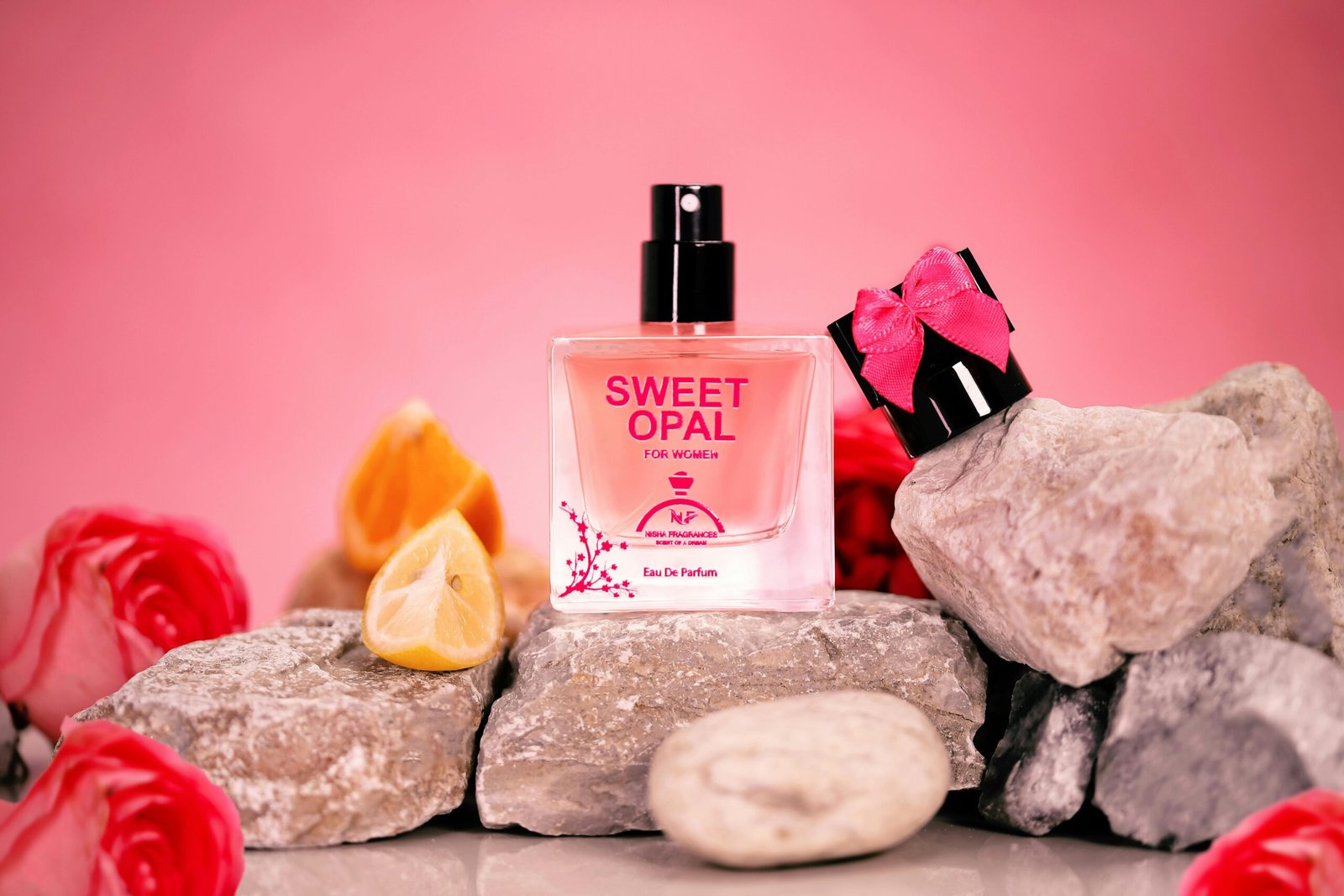 Elegant Sweet Opal perfume bottle with floral decor on pink stones, creating a modern aesthetic.
